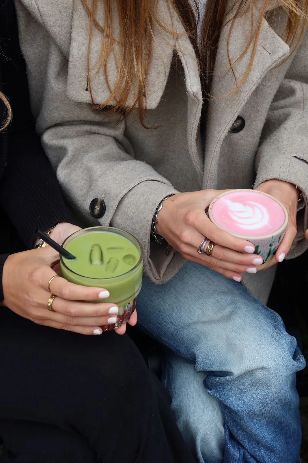 Iced Matcha und ein rosa Latte in den Händen